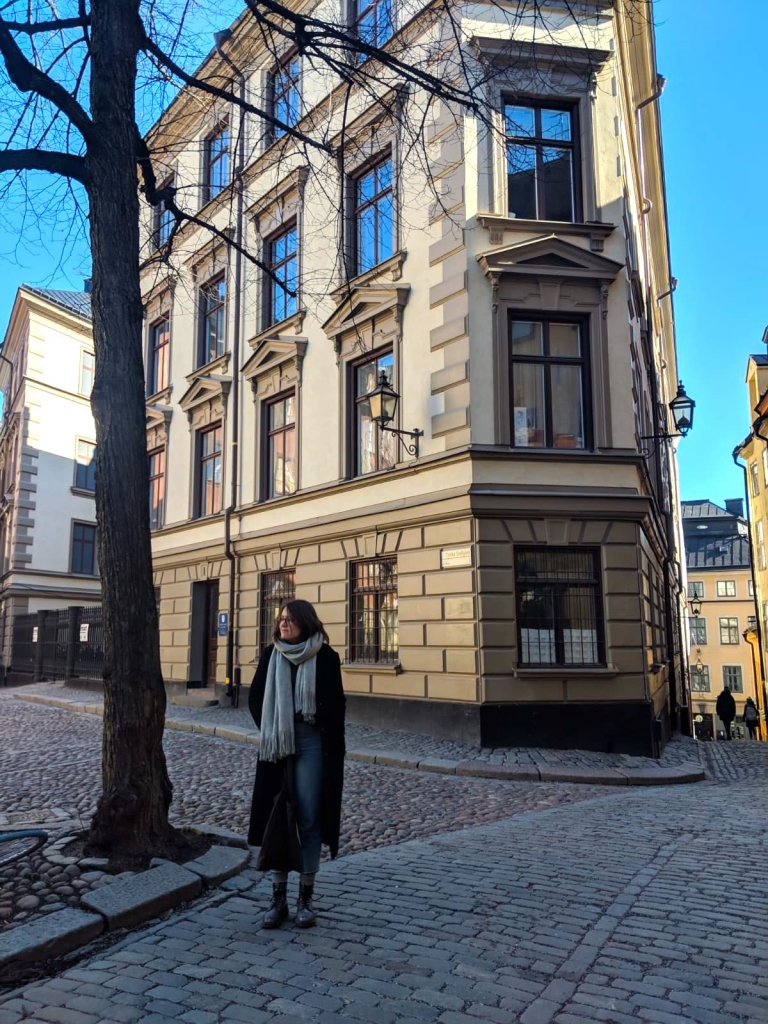 woman outside an old building under a tree