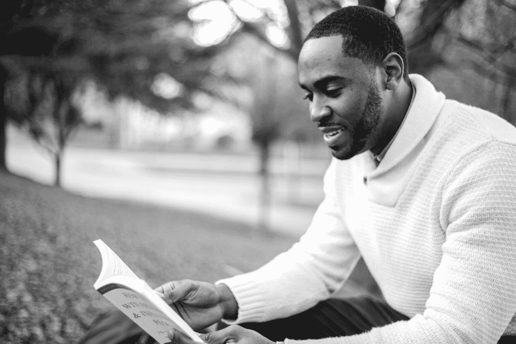 Man sitting in a park reading a book
